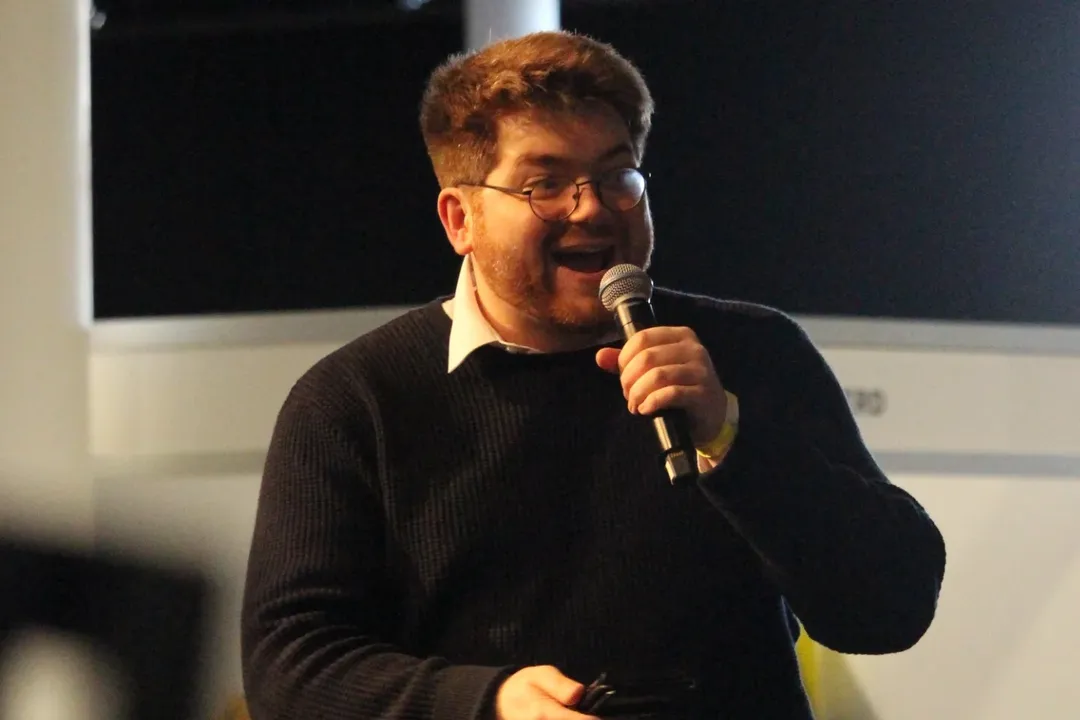 Callum Janes smiling on stage with a microphone